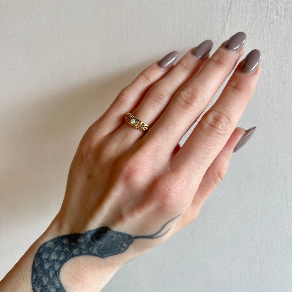 Communion by Joy gold band with opal on model, front view