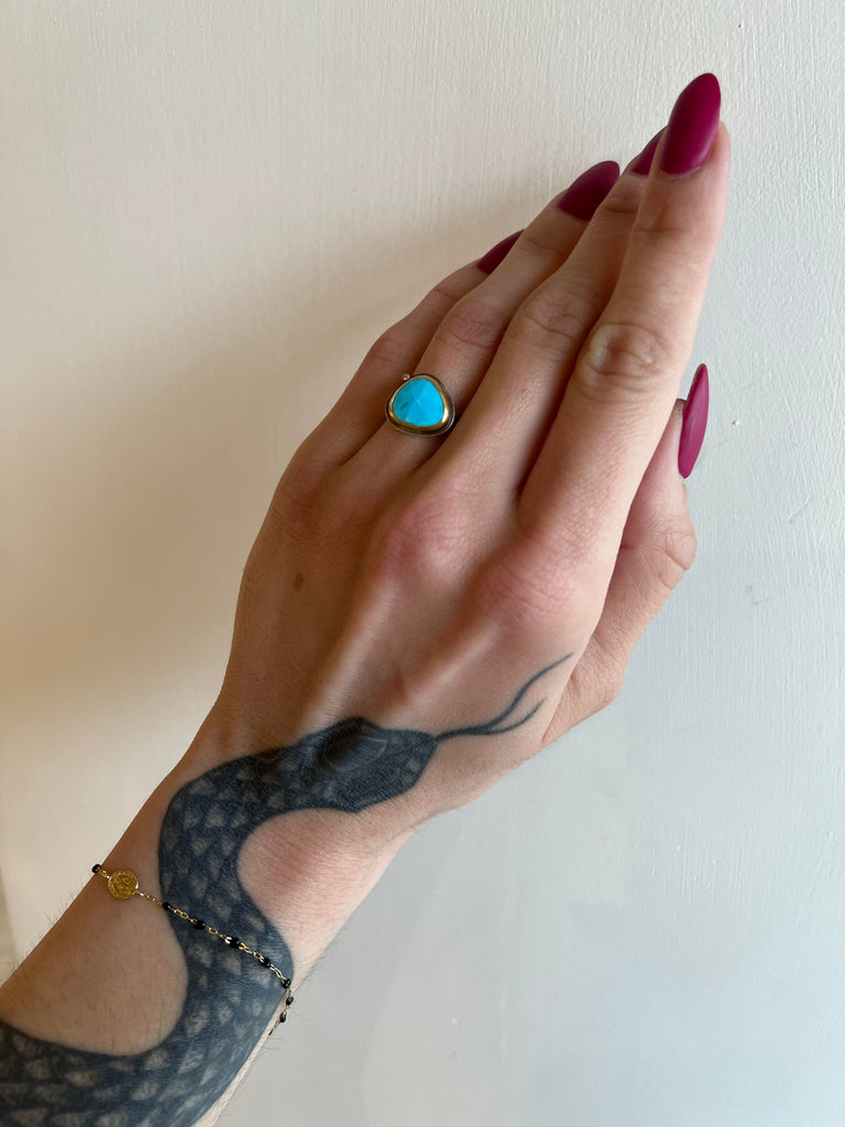 Ananda Khalsa silver ring with turquoise, gold, and diamond, on model top view