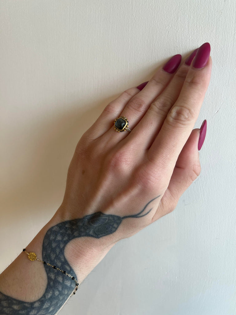 Ananda Khalsa silver ring with blue topaz, gold, and diamond on model, front view