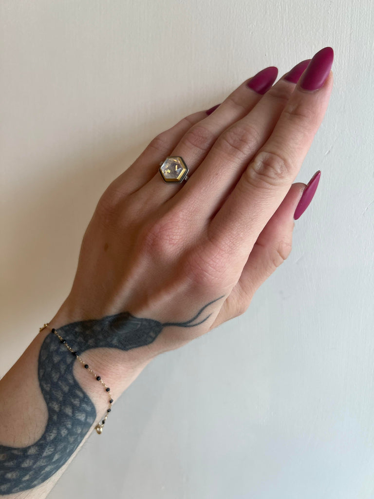 Ananda Khalsa silver ring with hexagonal moonstone and gold, on model, front view